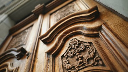 Téléchargez les photos : Artisanat des âges - Ornement élégant sur porte ancienne en bois dans l'architecture antique - en image libre de droit