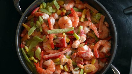 Téléchargez les photos : Préparation des crevettes et des légumes dans la casserole, Vue aérienne de la cuisson des repas de fruits de mer - en image libre de droit