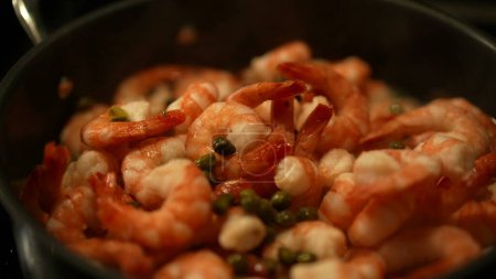Téléchargez les photos : Crevettes de fruits de mer à l'intérieur de la casserole avec vapeur de fumée, en ajoutant des ingrédients sur la préparation des aliments - en image libre de droit