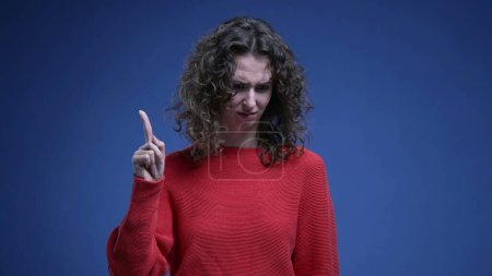 Foto de Mujer desconcertada reaccionando a la acusación con sorpresa, señalándose a sí misma rechazando la recriminación - agitando el dedo "no yo" en el lenguaje corporal - Imagen libre de derechos