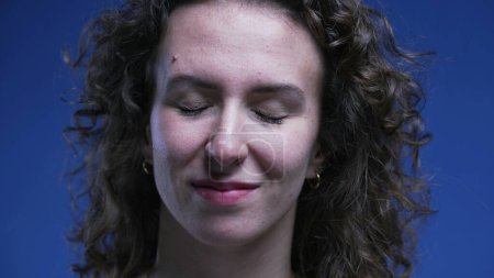Photo for Close-up face of woman closing eyes feeling relief smiling after accomplishing task. Stress-free emotion of 20s person feeling happy and relaxed - Royalty Free Image