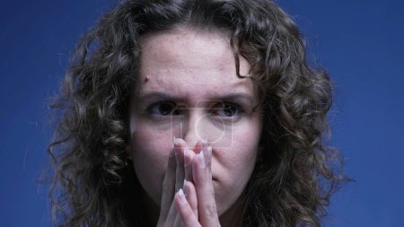 Photo for Anxious woman close-up face covering mouth with hand with preoccupied pensive expression, 20s female person struggling with mental angst - Royalty Free Image