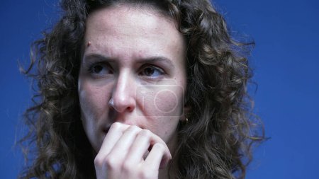 Photo for Nervous woman biting nails feeling hesitant, close-up face of female person in 20s feeling stress and preoccupation. anxious emotion - Royalty Free Image