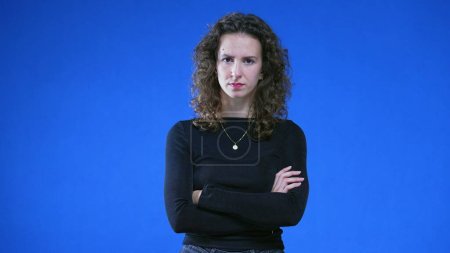 Foto de Mujer joven disgustada mostrando desaprobación, fondo azul. Enojado 20s persona sensación de molestia - Imagen libre de derechos