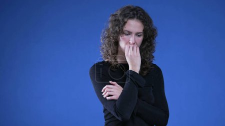 Foto de Mujer estresada mordiendo uñas luchando con la ansiedad y la presión mental. Persona con los brazos cruzados sintiéndose nerviosa y preocupada - Imagen libre de derechos
