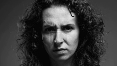 Photo for Serious concerned woman frowning and looking at camera in intense monochromatic black and white - Royalty Free Image