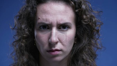 Téléchargez les photos : Femme bouleversée fronçant les sourcils avec une expression sérieuse regardant directement la caméra - en image libre de droit