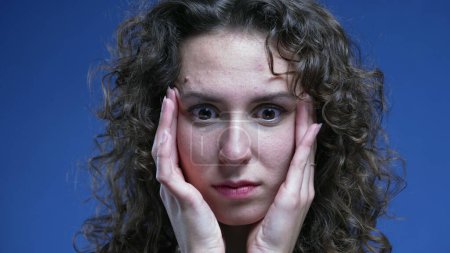 Téléchargez les photos : Stressé écrasé jeune femme essayant d'apaiser sa nervosité en mettant les mains sur le côté des tempes de la tête se sentant frustrationn et anxiété - en image libre de droit
