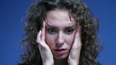 Photo for Stressed overwhelmed young woman trying to sooth her nervousness by putting hands on the side of head temples feeling frustrationn and anxiety - Royalty Free Image