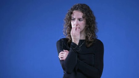 Téléchargez les photos : Femme stressée ongles mordants luttant contre l'anxiété et la pression mentale. Personne avec bras croisés se sentant nerveuse et préoccupée - en image libre de droit