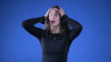 Photo for Anxious apprehensive woman reacting with shock and despair to news by putting arms on top of head and covering mouth in disbelief and surprise - Royalty Free Image