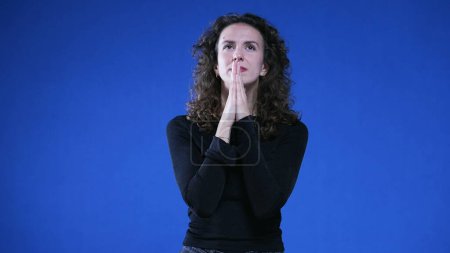 Photo for Woman Praying to God seeking help during difficult times. 20s female caucasian person closing eyes with HOPE and FAITH - Royalty Free Image