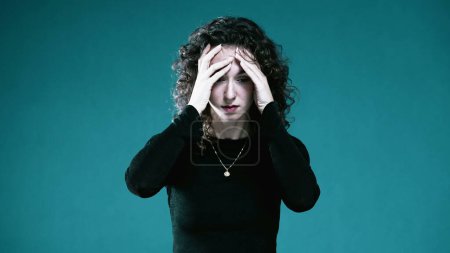 Photo for Tormented Woman with Face in Hands, Overwhelmed by Regret and Past Memories covers face in anguish - Royalty Free Image