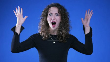 Photo for Woman Overwhelmed by Truth Revelation with Mind-Blowing Gesture on Blue Background, Shocked Woman Making Head Explosion Gesture Upon Realizing Eureka - Royalty Free Image