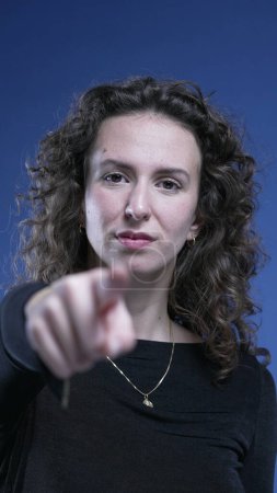 Foto de Mujer señalar con el dedo a la cámara diciendo USTED con el lenguaje corporal sobre fondo azul - Imagen libre de derechos