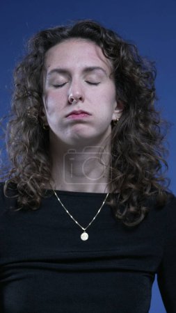 Foto de Mujer aburrida tomando un suspiro profundo sensación de agotamiento, primer plano de la cara exasperado 20s persona perder la paciencia y los ojos ondulantes - Imagen libre de derechos