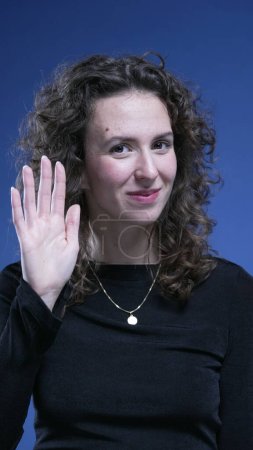 Photo for Shy woman waving hello with hand. Hesitant person saying HI with body gesture - Royalty Free Image