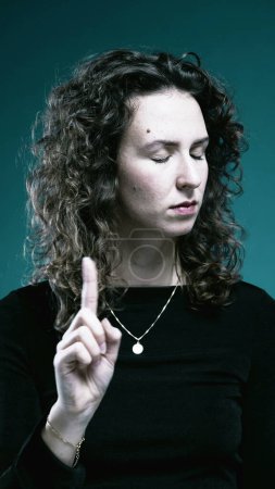 Photo for Upset woman says NO by waving finger rejecting offer, makes an X with arms, stern body language - Royalty Free Image