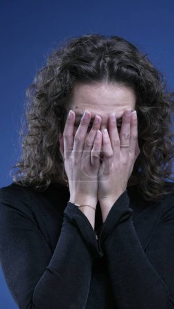 Foto de Mujer frustrada cubriendo la cara de vergüenza sintiendo pesar y desesperación - Imagen libre de derechos