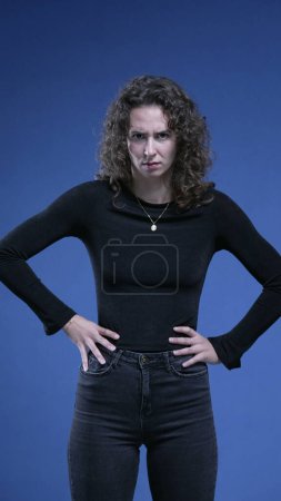 Photo for Upset woman putting hands on side of hips feeling judgemental and angry posture, stern serious person expression - Royalty Free Image