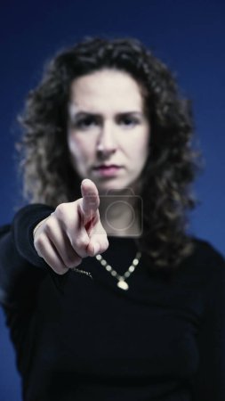 Photo for Close-Up of Stern Woman Waving Finger Saying No on blue backdrop - Royalty Free Image