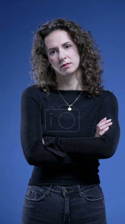Photo for Angry woman with arms crossed looking at camera with upset expression - Royalty Free Image