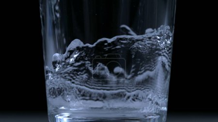 Téléchargez les photos : Verser de l'eau dans une tasse en verre au ralenti à 1000 ips capturée avec une caméra haute vitesse - en image libre de droit