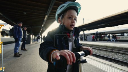 Photo for Child in Helmet with Scooter Awaiting Train - Fall to Winter Season Gear - Royalty Free Image