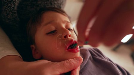 Téléchargez les photos : Gros plan sur le visage de l'enfant pendant que la mère se brosse les dents, hygiène dentaire la nuit avant le coucher, bouche du jeune garçon pendant l'hygiène dentaire - en image libre de droit