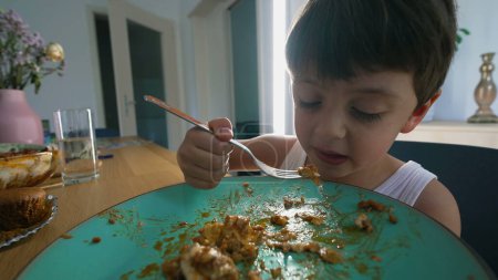 Photo for Young boy eating lunch at home meal, child using fork to eat food - Royalty Free Image