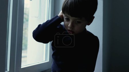 Photo for Child Struggling with Mental Illness, Seated by Window feeling depressed and lonely, stuck indoors feeling solitude and loneliness - Royalty Free Image