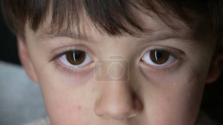 Foto de Primer plano de los ojos del niño mirando fijamente a la cámara capturada con una lente macro. Joven chico ojo vista - Imagen libre de derechos