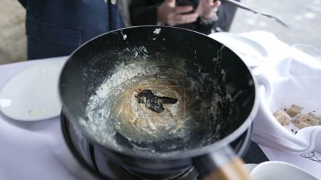 Foto de Terminado fondue, resultado final de plato de corteza de queso, "religieuse" durante el estado final final de la cocina tradicional suiza, pan vacío permanece - Imagen libre de derechos