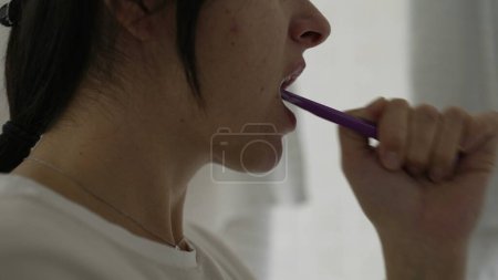 Photo for Closeup woman's mouth brushing teeth during morning ritual. Dental hygiene of person during everyday domestic ritual activity - Royalty Free Image