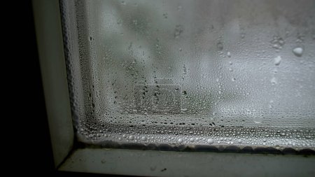 Foto de La condensación sobre el cristal durante el tiempo frío, la temporada invernal la manifestación de las gotitas en macro el primer plano en la ventana - Imagen libre de derechos