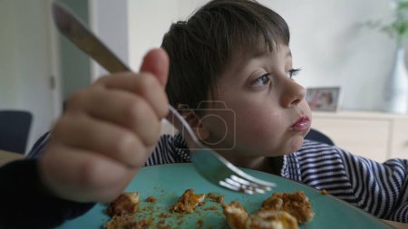 Photo for Child talking with mouth full of food during lunch time - Royalty Free Image