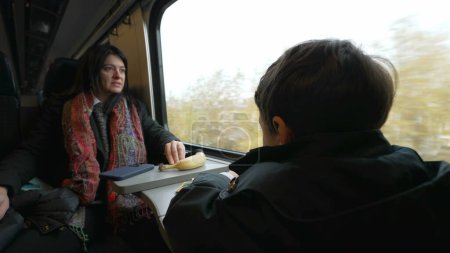 Photo for Mother and child traveling by train, back of little boy seated by window on high-speed transportation during fall season wearing scarf and jacket - Royalty Free Image