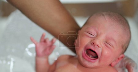 Foto de Newborn baby boy crying while taking bath - Imagen libre de derechos