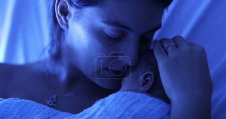 Foto de Mother holding newborn baby at hospital next to violet phototherapy lamp, real life affection and love - Imagen libre de derechos
