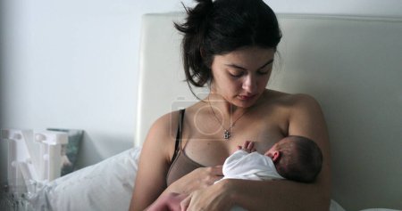 Foto de Candid mom breastfeeding infant newborn baby, new mother showing love and affection - Imagen libre de derechos