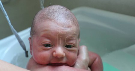 Photo for Close-up of baby in small bathtub, Washing little newborn baby face and body - Royalty Free Image
