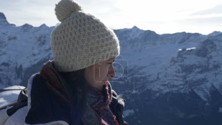 Photo for Meditative woman in 30s closing eyes in contemplation amidst mountains in high peak. Contemplative person wearing winter clothes reflecting on life, peaceful solitude - Royalty Free Image