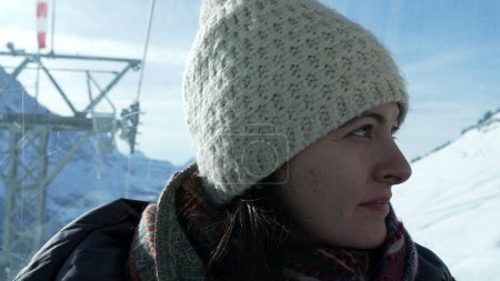 Téléchargez les photos : Femme à l'intérieur ascenseur transport bénéficiant d'une vue d'en haut pendant la saison de ski d'hiver - en image libre de droit