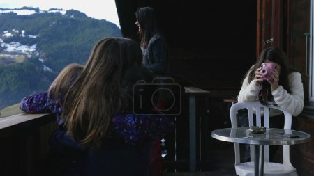 Photo for Mother Taking Polaroid Photo of Children on Chalet Balcony during ski vacation in Switzerland - Royalty Free Image