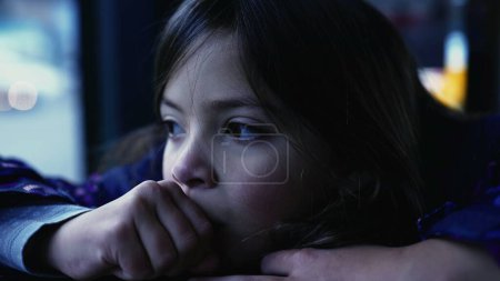 Foto de Thoughtful little girl daydreaming, closeup of pensive 8 year old child face in deep introspection staring at view from bus window - Imagen libre de derechos