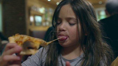 Photo for Children grabbing slice of pizza at restaurant, siblings about to eat carb food at diner. Little girl eating pizza - Royalty Free Image