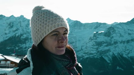 Photo for Mindful woman enjoying the Swiss Alps overlooking scenic mountain covered in snow backdrop. Pensive introspective person in 30s contemplating nature - Royalty Free Image
