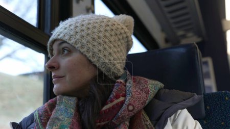 Téléchargez les photos : Passagère assise près de la fenêtre et regardant passer la vue depuis le confort du train pendant la saison hivernale - en image libre de droit