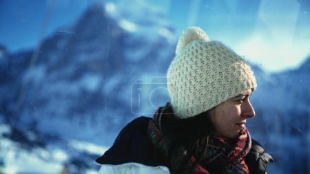 Téléchargez les photos : Femme contemplative des années 30 bénéficiant d'une vue sur la saison froide depuis le haut dans les montagnes. Personne méditative portant un bonnet et un foulard portrait - en image libre de droit