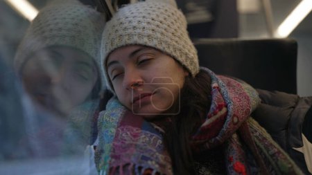 Foto de Mujer viajera se despierta de la siesta dentro del transporte del tren después de haber perdido la parada y levantarse del asiento. Pasajero dormido despertando - Imagen libre de derechos